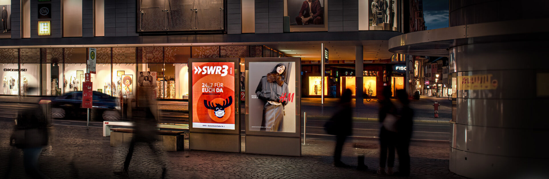 CityLight-Poster in Konstanz, Bodanplatz, nachts beleuchtet mit H&M Werbung