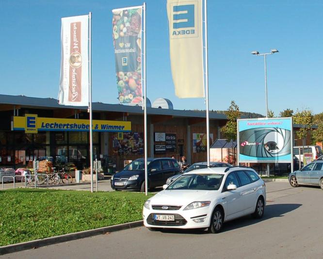 Werbeanlage auf dem Parkplatz eines Verbrauchermarktes neben der Zufahrt.