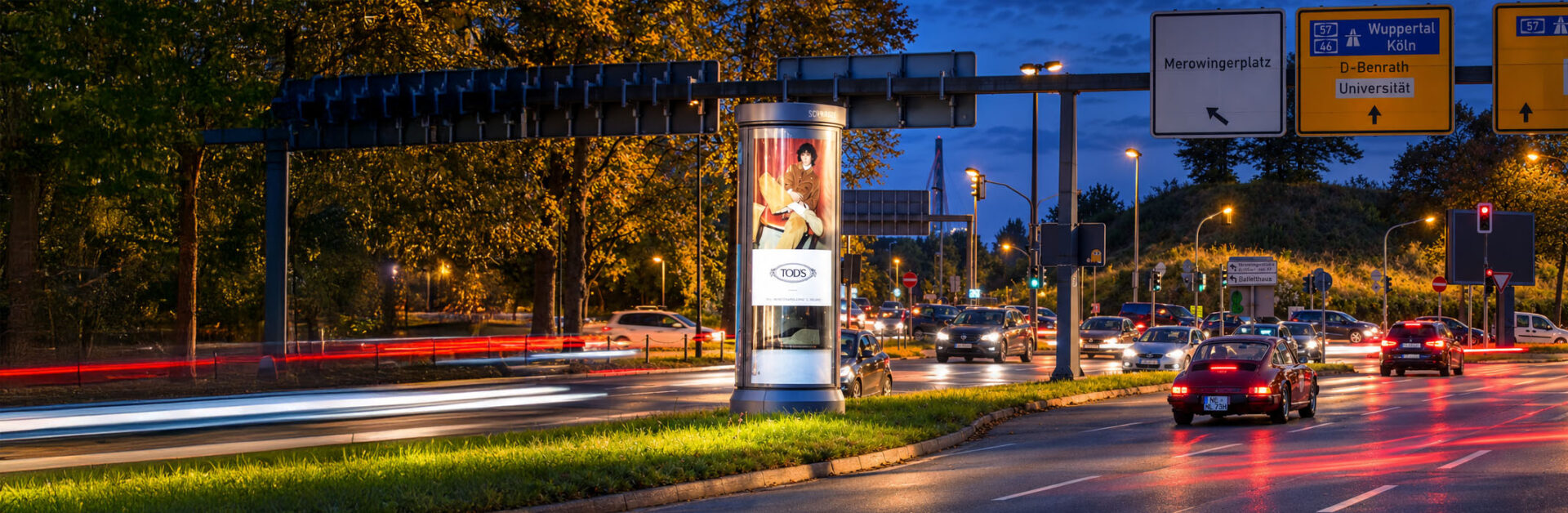 Beleuchtete Premium Citylight-Säule von Schwarz Außenwerbung mit TODS-Kampagne in Düsseldorf bei Nacht